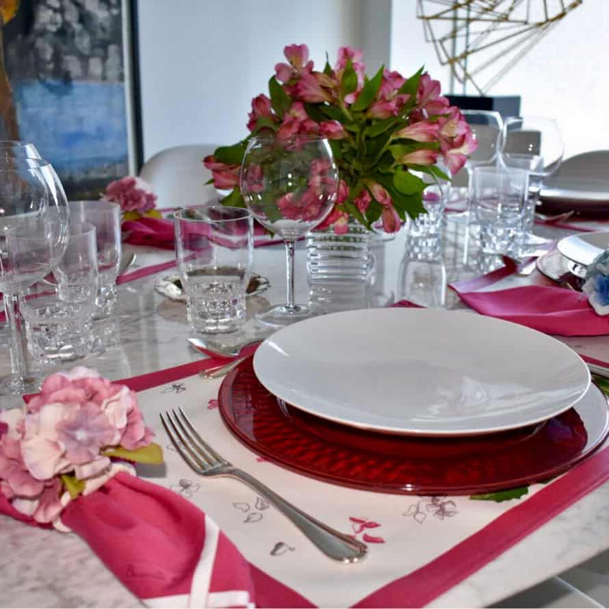 Una mesa servida para un almuerzo con colore que contrastan con la vajilla blanca