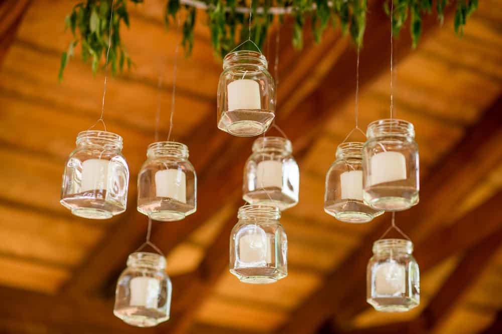 Una idea preciosa y muy decorativa es suspender pequeños frascos de vidrio con velitas dentro
