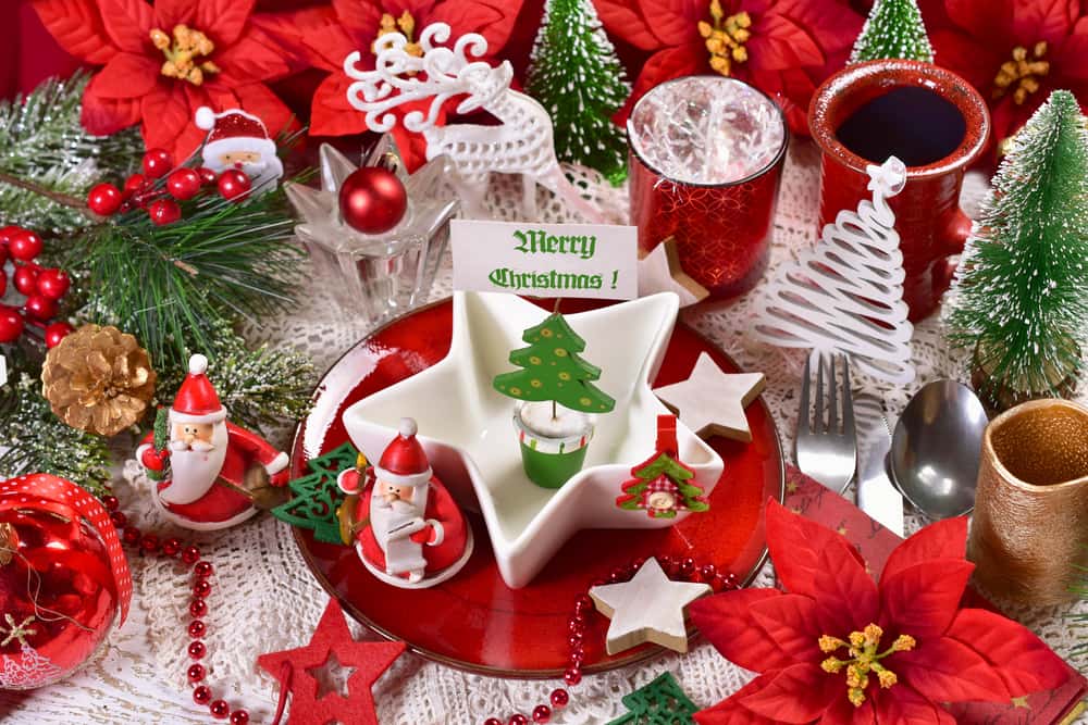 Las flores de navidad en la mesa le dan un toque fresco y natural. Mezcla con adornos como estrellas, pequeños Santas y velas para resaltar la decoración de la mesa.