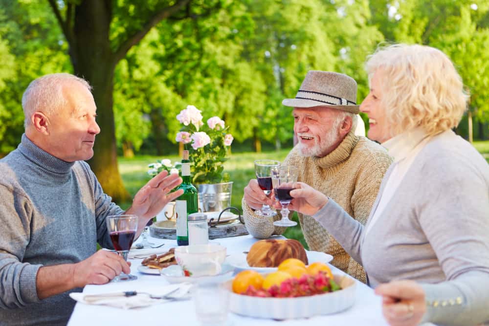 Los habitantes de una zona azul disfrutan tomar una copa de vino tinto con sus amigos. la socialización es parte del proceso de envejecer feliz.